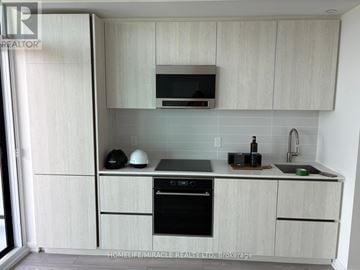Toronto (Waterfront Communities) condo for rent - A kitchen with white cabinets and a black oven.