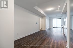Burlington (Brant) condo for rent - A spacious room with wooden floors and white walls.