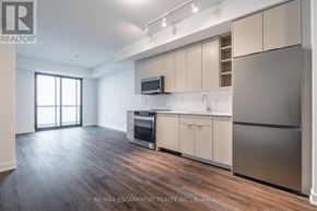 Burlington (Brant) condo for rent - A modern kitchen with wooden floors and stainless steel appliances.