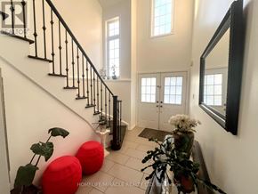 Brantford apartment for rent - A hallway with a staircase, a mirror, and a door.
