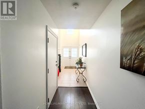 Brantford apartment for rent - A hallway with a plant on a table and a painting on the wall.