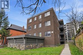 Hamilton (Strathcona) multi-family for rent - A building with a stone wall in front of it.