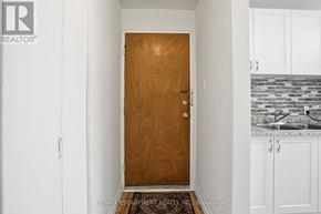 Hamilton (Strathcona) multi-family for rent - A brown door is in the middle of a white hallway.