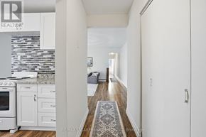 Hamilton (Strathcona) multi-family for rent - A hallway with a rug on the floor and a kitchen area to the left.