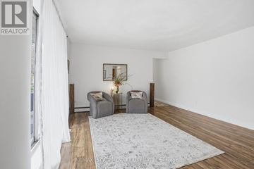 Hamilton (Strathcona) multi-family for rent - A living room with a grey rug and two grey armchairs.