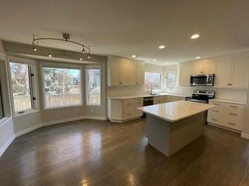 Winnipeg apartment for rent - A kitchen with white cabinets and a large island in the middle.