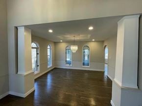 Winnipeg apartment for rent - A spacious room with wooden floors and white walls.