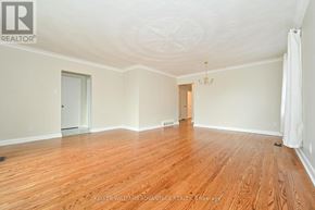 Toronto (Wexford-Maryvale) apartment for rent - A spacious room with wooden floors and white walls.