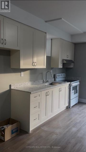 Pickering apartment for rent - A kitchen with white cabinets and a grey countertop.
