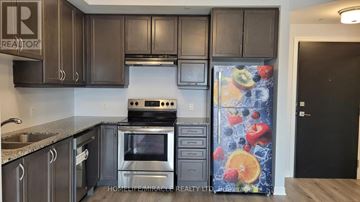 Brampton (Northwest Brampton) condo for rent - A kitchen with dark brown cabinets and a stove top oven.