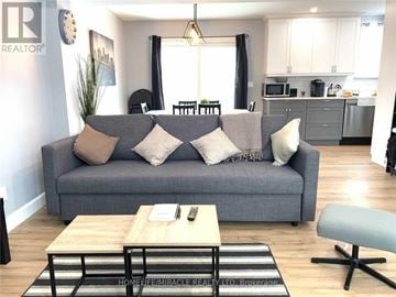 Niagara Falls (Hospital) apartment for rent - A grey couch with a remote on the coffee table in the living room.