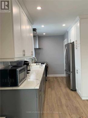 Niagara Falls (Hospital) apartment for rent - A kitchen with white cabinets and a grey refrigerator.