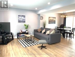 Niagara Falls (Hospital) apartment for rent - A living room with a grey couch, a coffee table, and a TV.