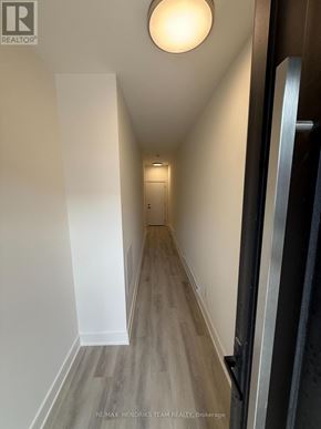 St. Catharines (Oakdale) townhouse for rent - A hallway with wood flooring and white walls.