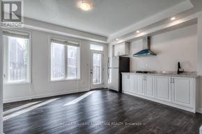 Toronto (Clairlea-Birchmount) apartment for rent - A spacious kitchen with white cabinets and a stainless steel refrigerator.