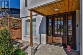 Caledon (Bolton West) apartment for rent - A modern house with a wooden door and a sign that says "REAL ESTATE HOMEWARD, Brokerage".