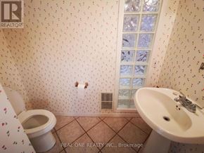 Mississauga (Erindale) apartment for rent - A bathroom with a toilet, sink, and wallpapered walls.