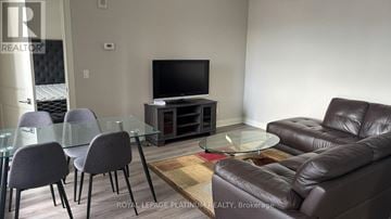 Hamilton (Central) condo for rent - A living room with a glass table and leather couch.