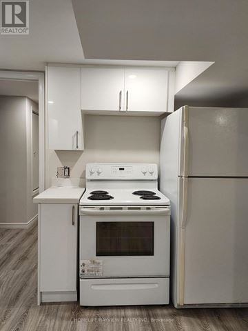 East Gwillimbury (Holland Landing) apartment for rent - A white kitchen with a stove and refrigerator.