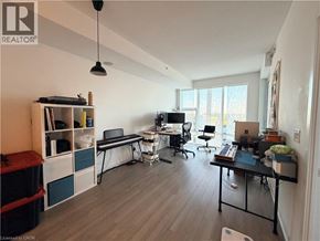 Kitchener condo for rent - A well-lit room with a desk, chairs, and a laptop.