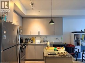 Kitchener condo for rent - A kitchen with a refrigerator, sink, and countertop.