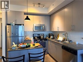 Kitchener condo for rent - A modern kitchen with a granite countertop and stainless steel appliances.