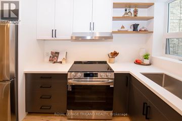 London East (East K) apartment for rent - A modern kitchen with a stainless steel refrigerator, a stove with an oven, and white cabinets.