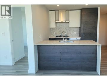 Vancouver apartment for rent - A kitchen with a wooden island and white cabinets.