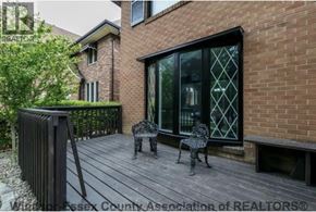 Windsor apartment for rent - A patio with a table and two chairs is in front of a brick house.