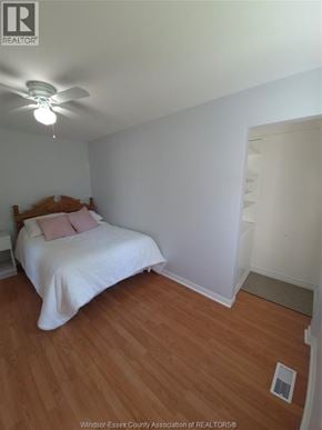 Windsor apartment for rent - A bedroom with a bed, a ceiling fan, and a wooden floor.