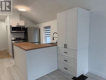 Aurora (Aurora Village) multi-family for rent - A kitchen with white cabinets and a wooden countertop.