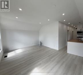 Aurora (Aurora Village) multi-family for rent - A spacious room with wooden flooring and white walls.