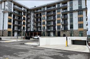 Waterloo condo for rent - A large apartment complex with a parking lot in front.