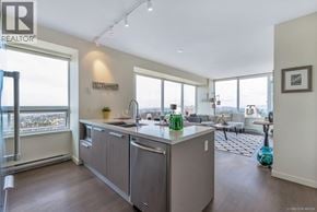 Burnaby apartment for rent - A modern kitchen with a large island and a view of the city.