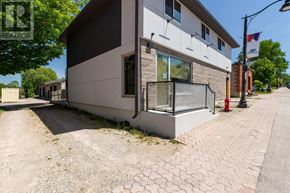 Arran-Elderslie apartment for rent - A modern house with a grey and white exterior and a brick pathway leading to the front door.