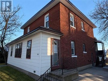 Sudbury apartment for rent - A red brick house with a white front porch.