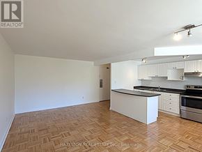 Toronto (Rosedale-Moore Park) condo for rent - A well-lit, empty kitchen with wooden flooring and white cabinetry.