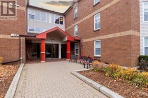 St. John's house for rent - A brick building with a red roof and a sign that says REALTOR.