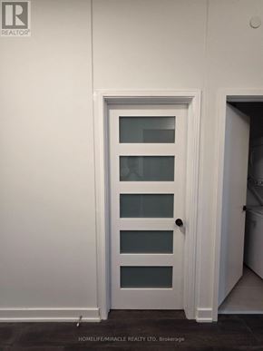 Toronto (Clairlea-Birchmount) condo for rent - A room with wooden flooring and white walls.