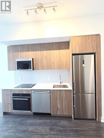 Toronto (Clairlea-Birchmount) condo for rent - A kitchen with wooden cabinets and stainless steel appliances.