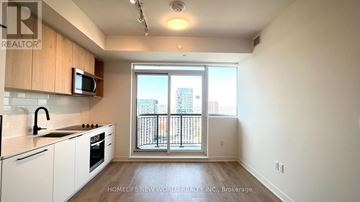 Toronto (Dovercourt-Wallace Emerson-Junction) condo for rent - A kitchen with white cabinets and a microwave on top of the counter.