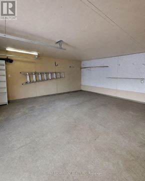 Brantford apartment for rent - A large, empty room with a concrete floor and walls, and a row of shelves on the wall.
