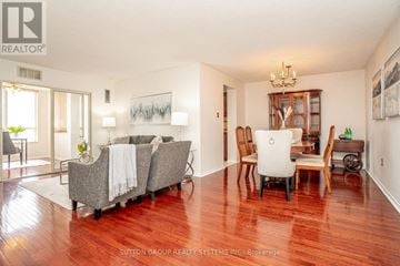 Brampton (Fletcher's Creek South) condo for rent - A living room with a grey sofa and a wooden floor.