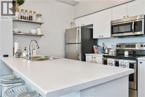 Hamilton condo for rent - A kitchen with a white countertop and stainless steel appliances.