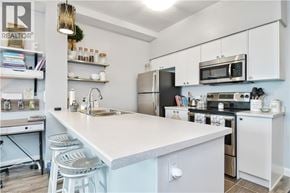Hamilton condo for rent - A kitchen with white cabinets and a white island with a sink.