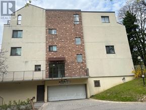 Toronto (Hillcrest Village) townhouse for rent - A two-story building with a garage door and a balcony.