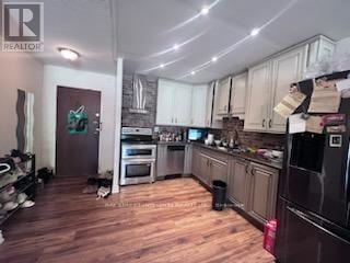Toronto (Hillcrest Village) townhouse for rent - A kitchen with wooden floors and a large island.