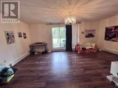 Toronto (Hillcrest Village) townhouse for rent - A large, empty room with wood flooring and a chandelier.