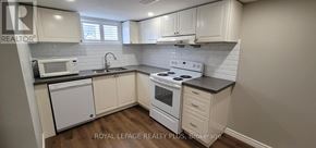 Hamilton (Inch Park) apartment for rent - A kitchen with white cabinets and a black countertop.
