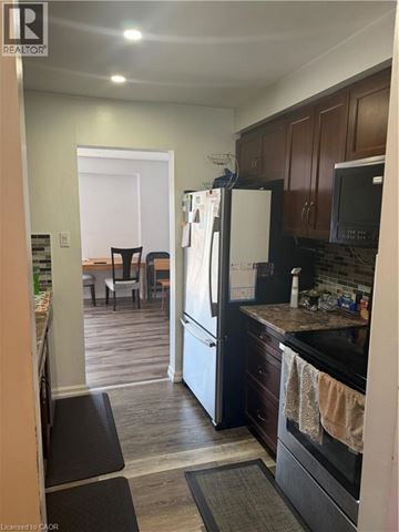 Hamilton condo for rent - A kitchen with a black refrigerator and black oven.